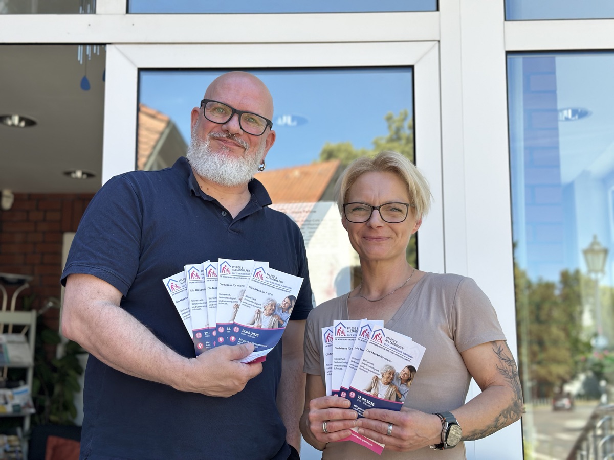 Herr Fontana und Frau Melanie Gießner halten Flyer zur Messe Pflege und Alltagshilfen.